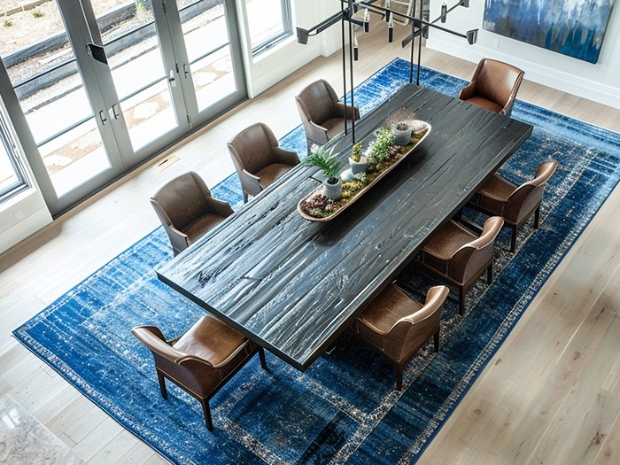 Un tapis texturé sous une grande table de salle à manger.