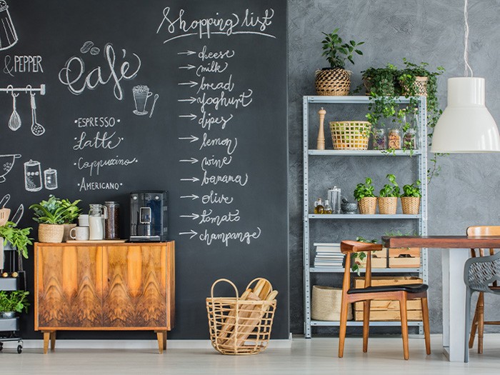 Cuisine avec un mur en tableau noir avec des motifs créatifs et une liste de courses.