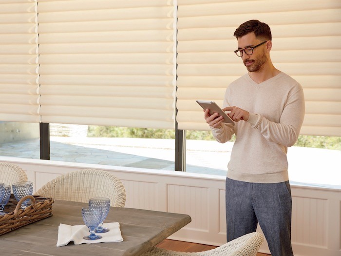 Man with iPad using it to operate his shade via an app.