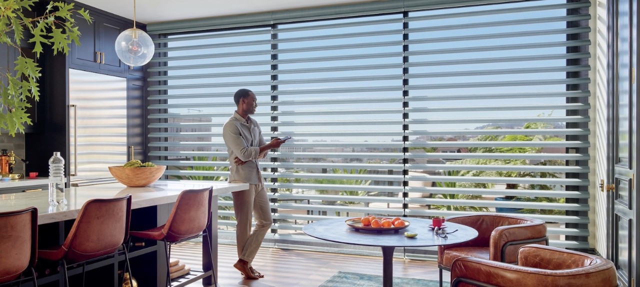 Kitchen with man using phone to operate shade